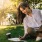 Woman sitting on grass on computer
